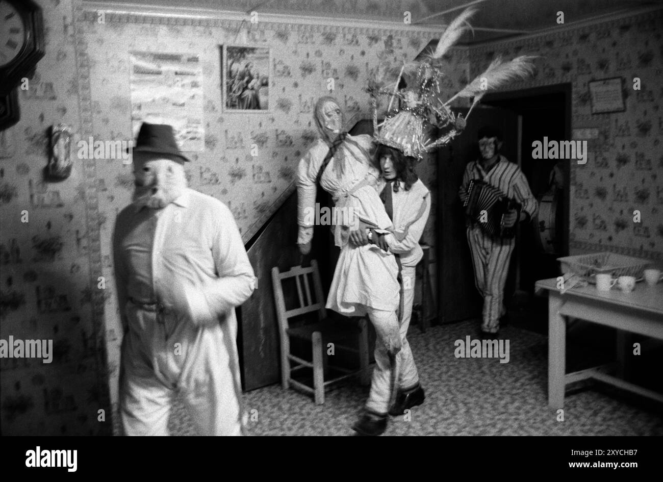 Biddy Boys, tradizionale festa annuale del folclore irlandese. Una festa per celebrare il Santo celtico, St Brigit o St Brigid. Un'effigie del Santo, nota come Biddy, viene portata in una casa, dove si svolgeranno musica e balli. L'uomo che porta il Biddy indossa un cappello di paglia tradizionale. Alla fine viene fatta una raccolta, se non ci sono soldi la signora della casa dà una spilla ai Biddy Boys. Killorglin, Contea di Kerry, Irlanda del Sud febbraio 1972 1970s Eire HOMER SYKES Foto Stock