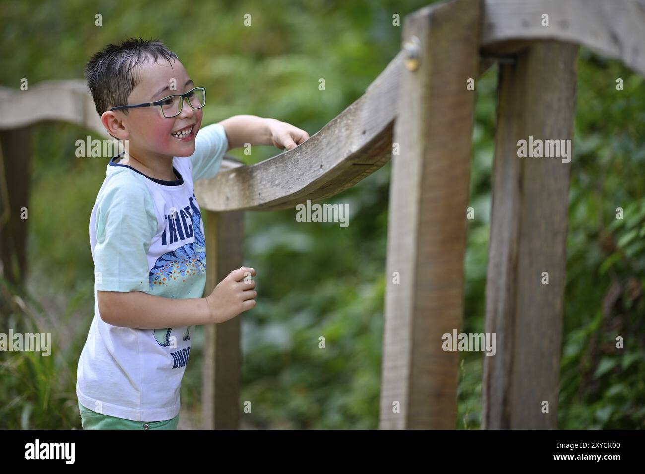 Bambino, ragazzo di 5 anni, multietnico, che gioca con le biglie sulla corsa di marmo XXL, NATURATUM Adventure Forest Trail, Schwaebisch Gmuend, Baden-Wuerttemberg, Ger Foto Stock