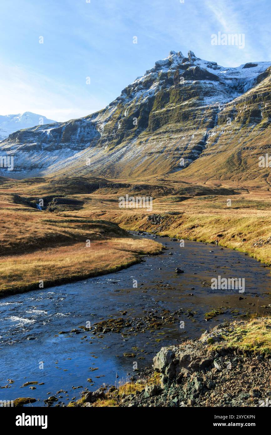Una catena montuosa con un fiume che la attraversa. Il fiume è blu e le montagne sono coperte di neve. La scena è tranquilla e serena Foto Stock