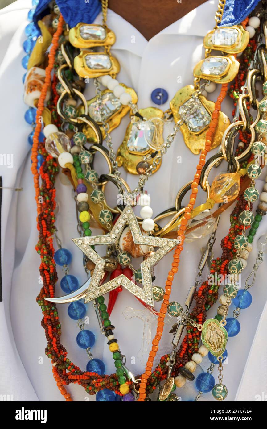 Collana utilizzata dall'uomo durante le tradizionali celebrazioni religiose in Brasile con simboli comuni la pratica dell'umbanda e della candela Foto Stock
