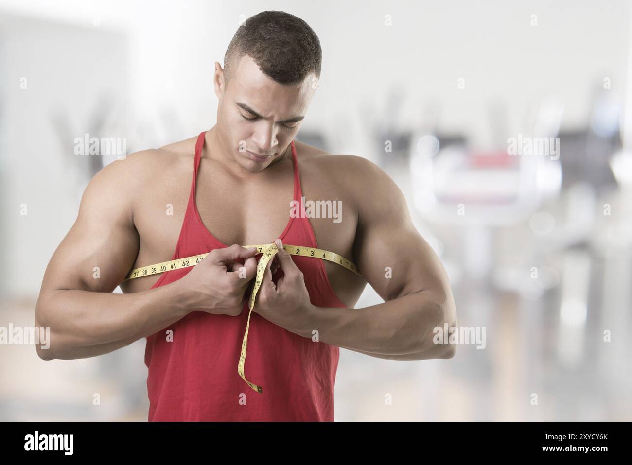 Maschio bodybuilder misurando il suo petto, in una palestra Foto Stock