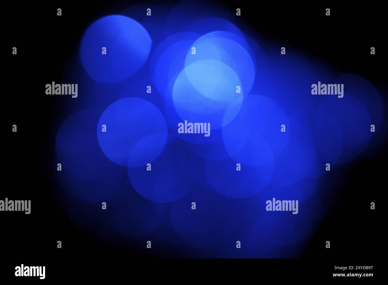 Blu luci sfocate, bokeh effetto. Foto reale dello sfondo. Isolato su nero Foto Stock