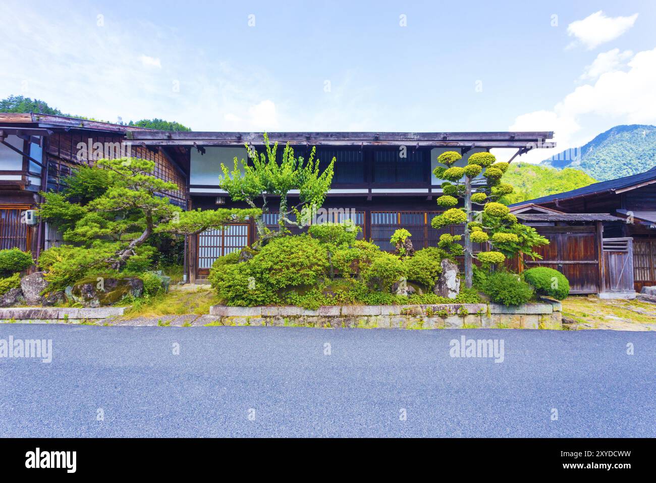 Di fronte ad una tradizionale casa in legno con giardino giapponese ben curato sulla via Nakasendo a Tsumago, Giappone, Asia Foto Stock