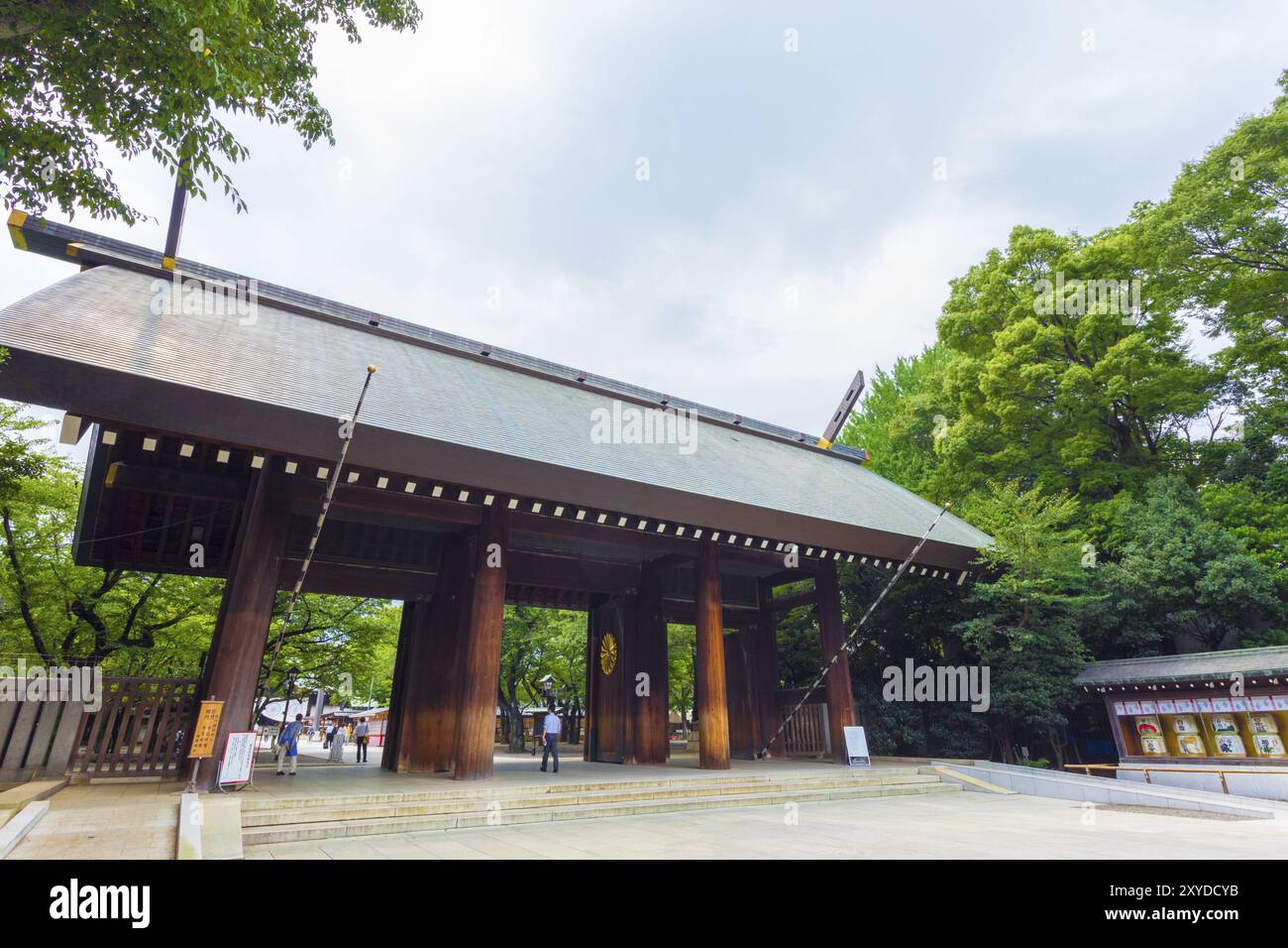 Tokyo, Giappone, 30 luglio 2015: Persone che camminano attraverso la porta di legno di Shinmon all'ingresso del controverso santuario shintoista di Yasukuni in un giorno cupo coperto. Foto Stock