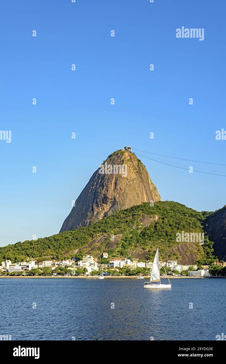 Piccole barche a vela vela la baia di Guanabara e passando di fronte alla collina di Sugar Loaf Foto Stock