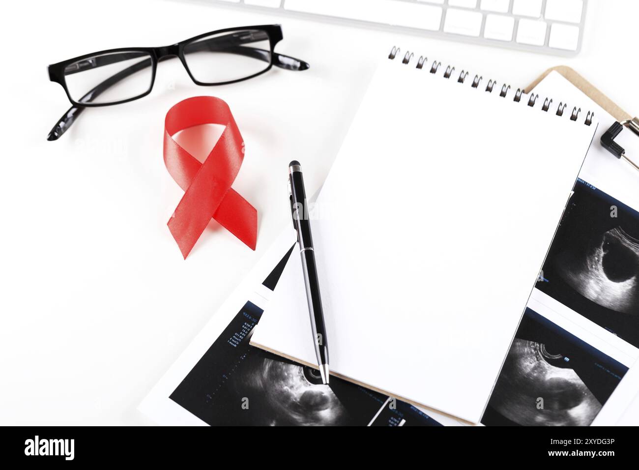 Sfondo medico con occhiali per tastiera a raggi X e blocco note, simbolo rosso del nastro della giornata mondiale del cancro, concetto Foto Stock