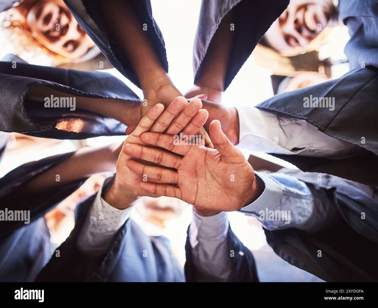 Persone, mani e pila per lauree, celebrazioni e università all'aperto con successo accademico. Studenti, motivazione e bassa angolazione per il raggiungimento dei risultati Foto Stock