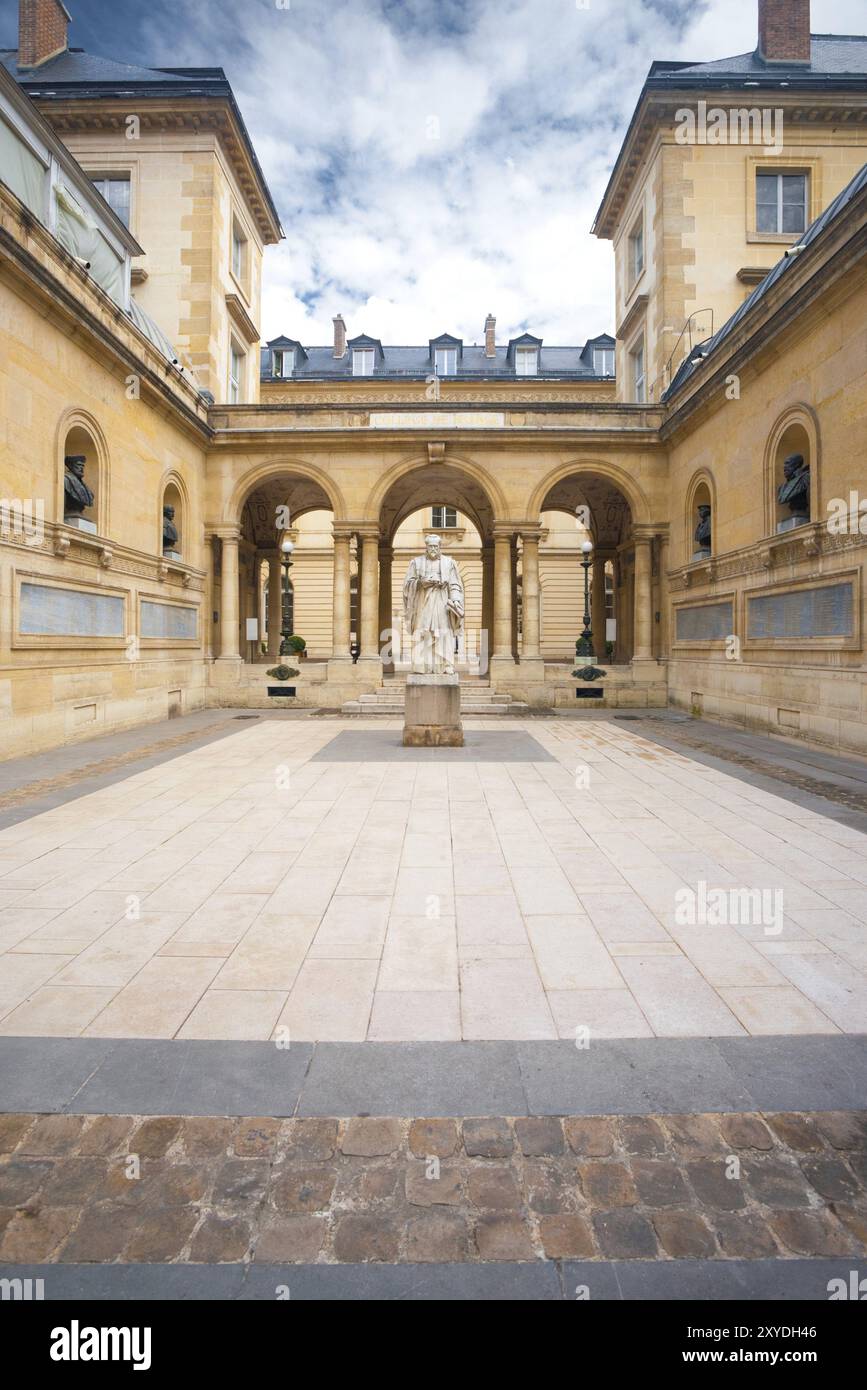 Architettura tradizionale in un bellissimo cortile antico del College de France, vicino alla Sorbona in Francia. Foto scattata dal marciapiede pubblico Foto Stock