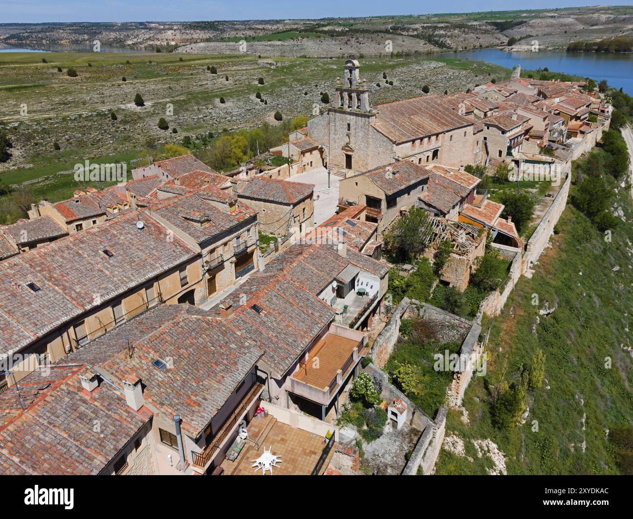 Un villaggio con case costruite da vicino e una grande chiesa nel mezzo di un paesaggio naturale, vista aerea, Maderuelo, Rio Riaza, fiume Riaza, Embalse d Foto Stock