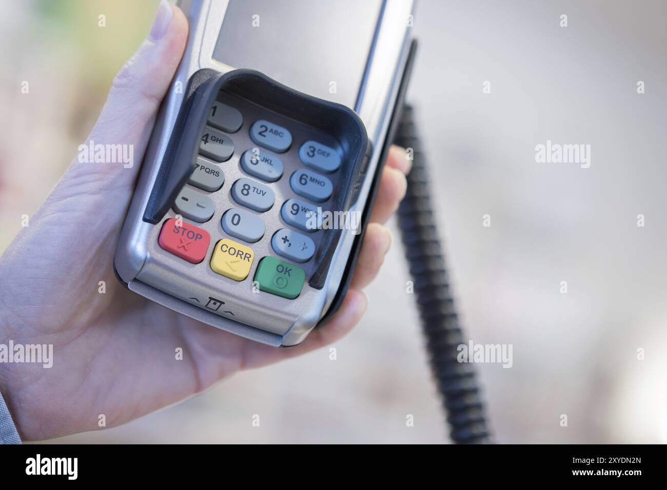 Proprietario del negozio è in possesso di un terminale di pagamento nella sua mano Foto Stock