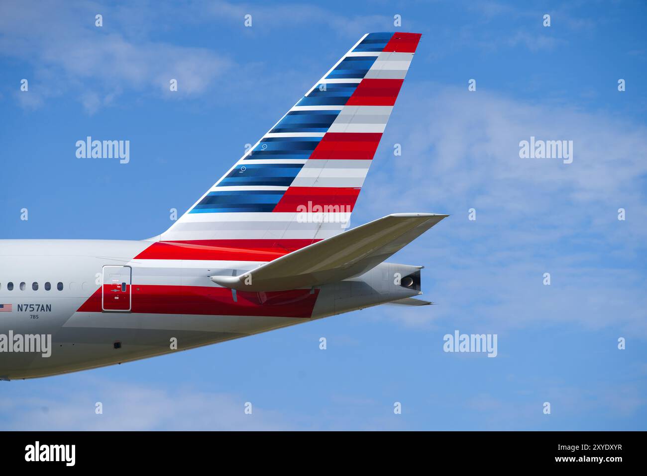 Boeing 777 dell'American Airlines atterrando con un cielo blu. Primo piano dell'ala del timone di coda. Londra - 28 agosto 2024 Foto Stock