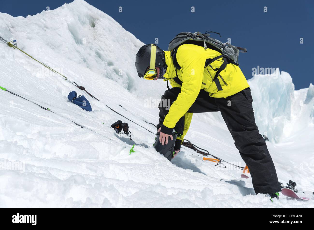 Uno sciatore professionista in piedi su un ghiacciaio si sta preparando per un salto mentre prepara l'attrezzatura da sci. Il concetto di formazione di qualità per lo sport Foto Stock