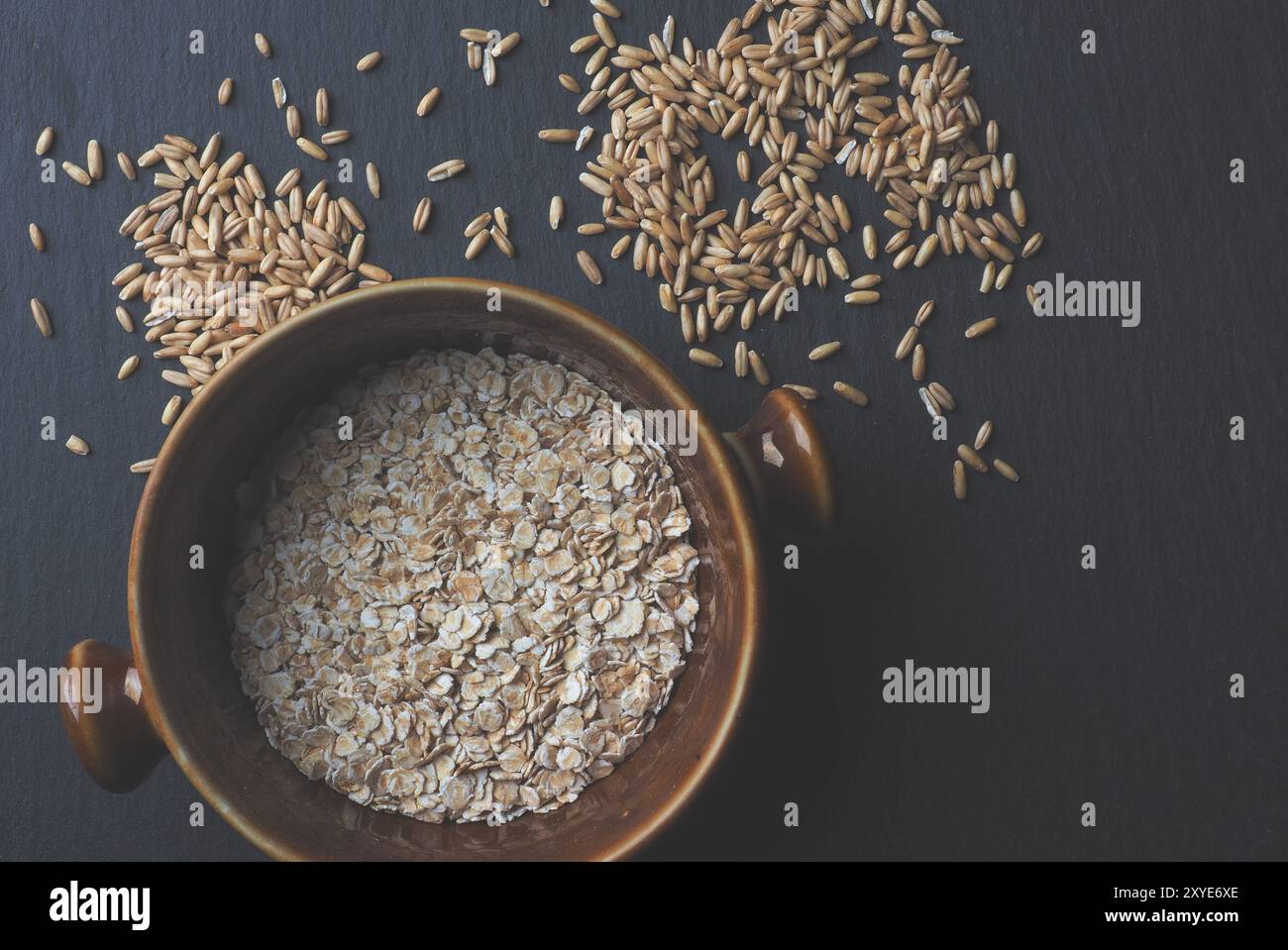 Sbucciate e Avena Farina di avena al buio su un tavolo di pietra, cibo sano concetto, vista da sopra Foto Stock