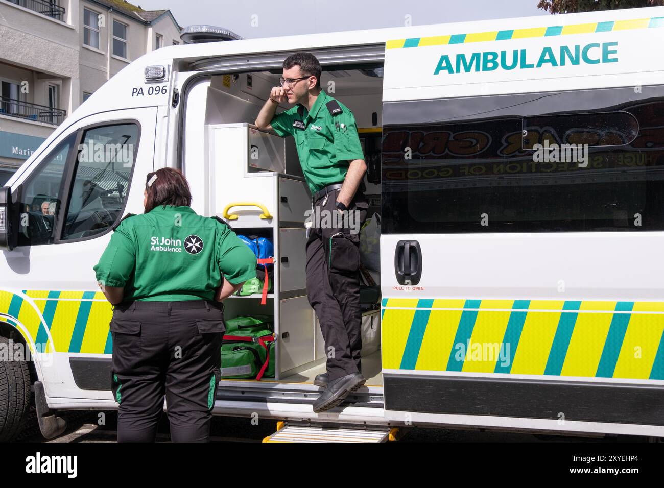 St John ambulanza volontari di pronto soccorso, uomo con occhiali in uniforme verde e nera che guarda fuori dall'ambulanza. Ballycastle, Regno Unito - 26 agosto 2024. Foto Stock