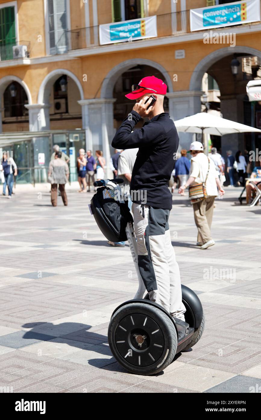Uomo che parla al telefono con il suo Segway Foto Stock