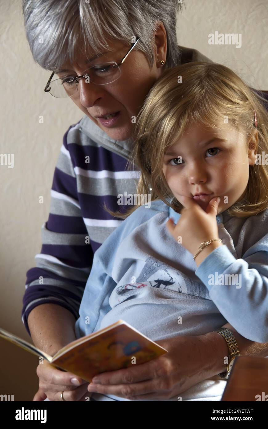 La nonna legge una storia della buonanotte a sua nipote Foto Stock