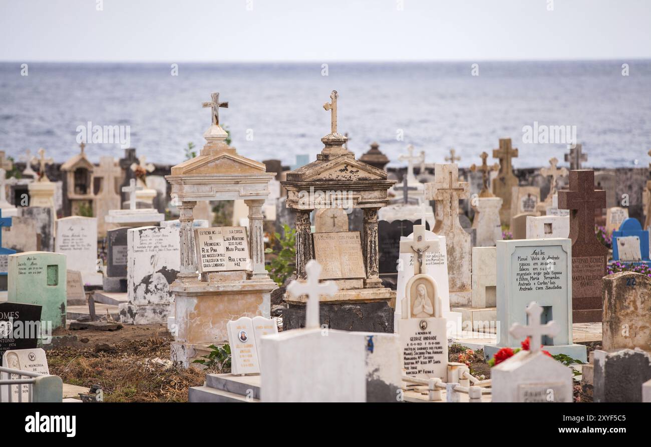 Lapidi in un vecchio cimitero cattolico con il mare sullo sfondo Foto Stock