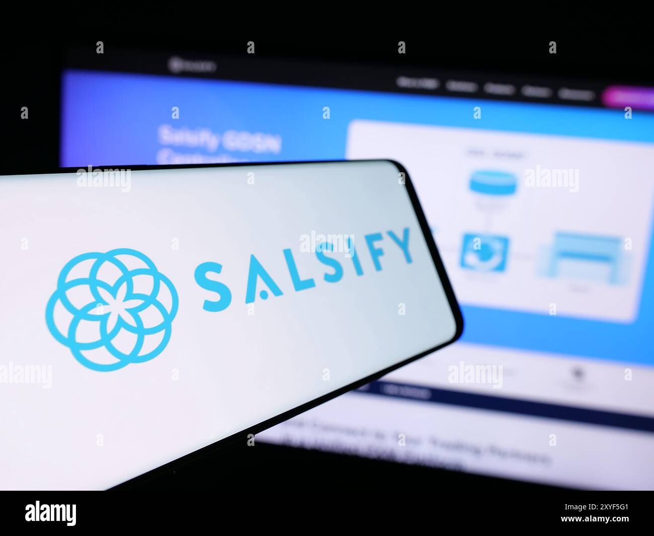 Telefono cellulare con sito Web della società americana di gestione dell'esperienza di prodotto Salsify Inc. Davanti al logo. Mettere a fuoco la parte sinistra del display del telefono. Foto Stock
