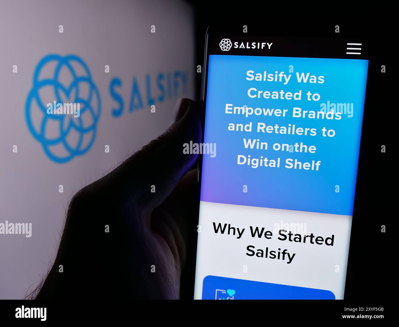 Persona che detiene un cellulare con pagina Web della società di gestione dell'esperienza di prodotto statunitense Salsify Inc. Davanti al logo. Messa a fuoco al centro del display del telefono. Foto Stock