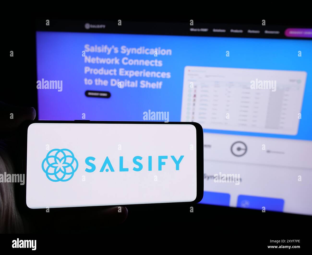 Persona che possiede un telefono cellulare con il logo della società americana di gestione dell'esperienza di prodotto Salsify Inc. Di fronte alla pagina Web. Mettere a fuoco il display del telefono. Foto Stock