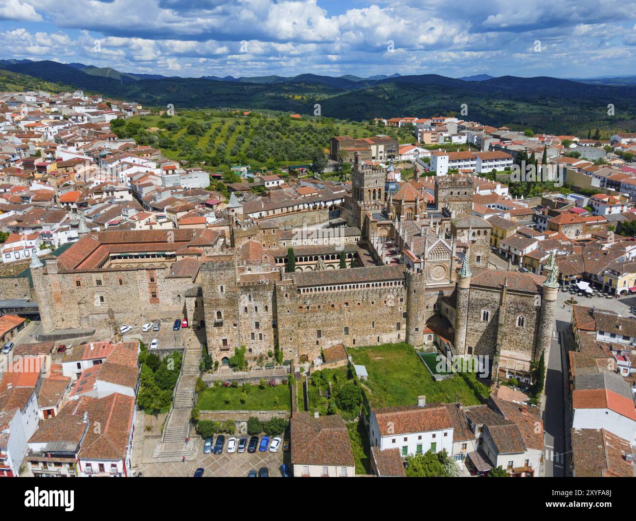 Vista aerea di un vecchio monastero con tetti rossi e aree verdi circostanti in un villaggio in Spagna. Architettura storica e bellezza paesaggistica. Vista aerea Foto Stock