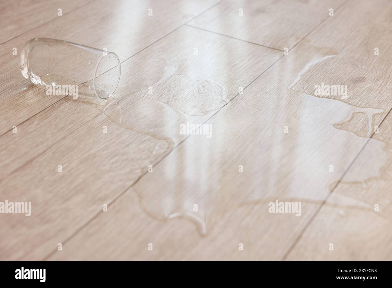 Bicchiere con bibita versata su pavimento in legno, primo piano Foto Stock