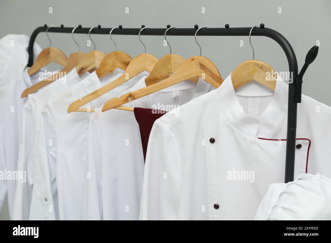 Uniformi degli chef su un appendiabiti su sfondo grigio, primo piano Foto Stock