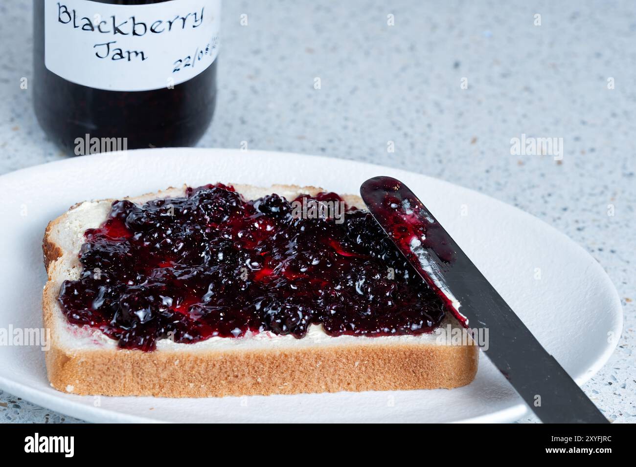 REGNO UNITO. Una fetta spessa di pane bianco spalmato con burro e marmellata di mora fatta in casa. Un sandwich aperto con marmellata Foto Stock