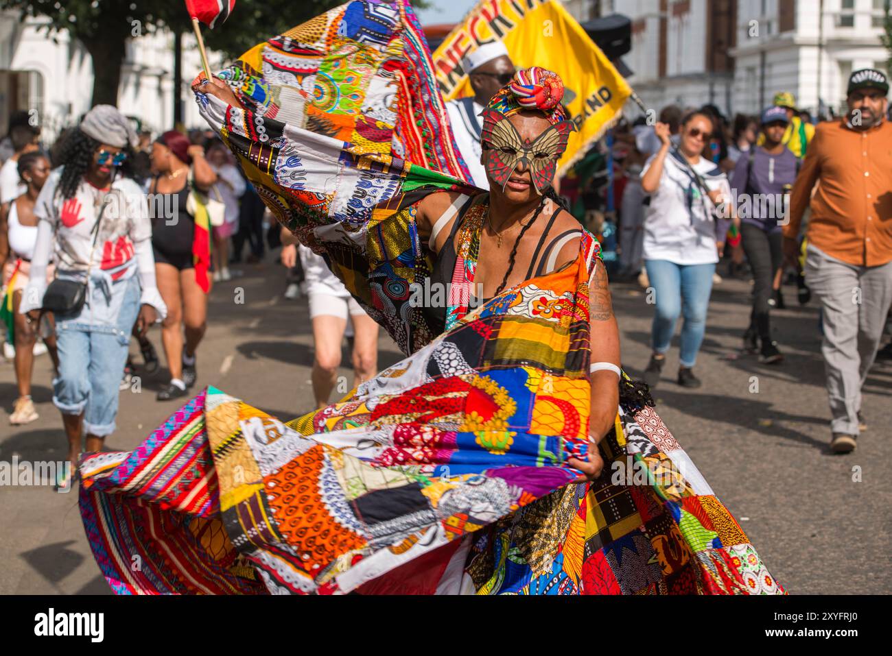 Durante l'annuale Carnevale di Notting Hill, gli artisti vestiti in modo elaborato nella Parata degli adulti procedono lentamente attraverso la parte occidentale di Londra Foto Stock