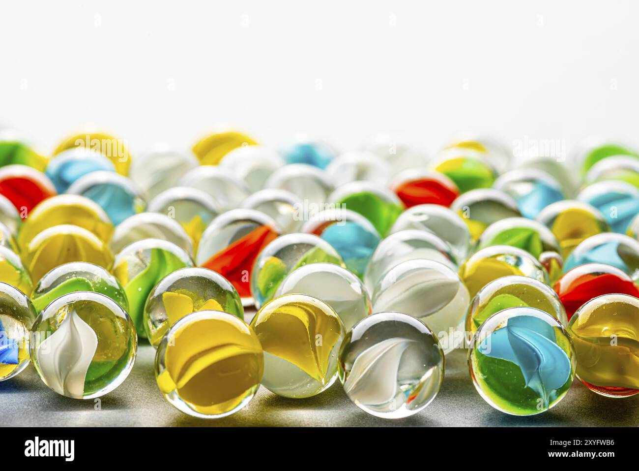 Marmi di vetro gialli, verdi, blu e rossi su un tavolo Foto Stock