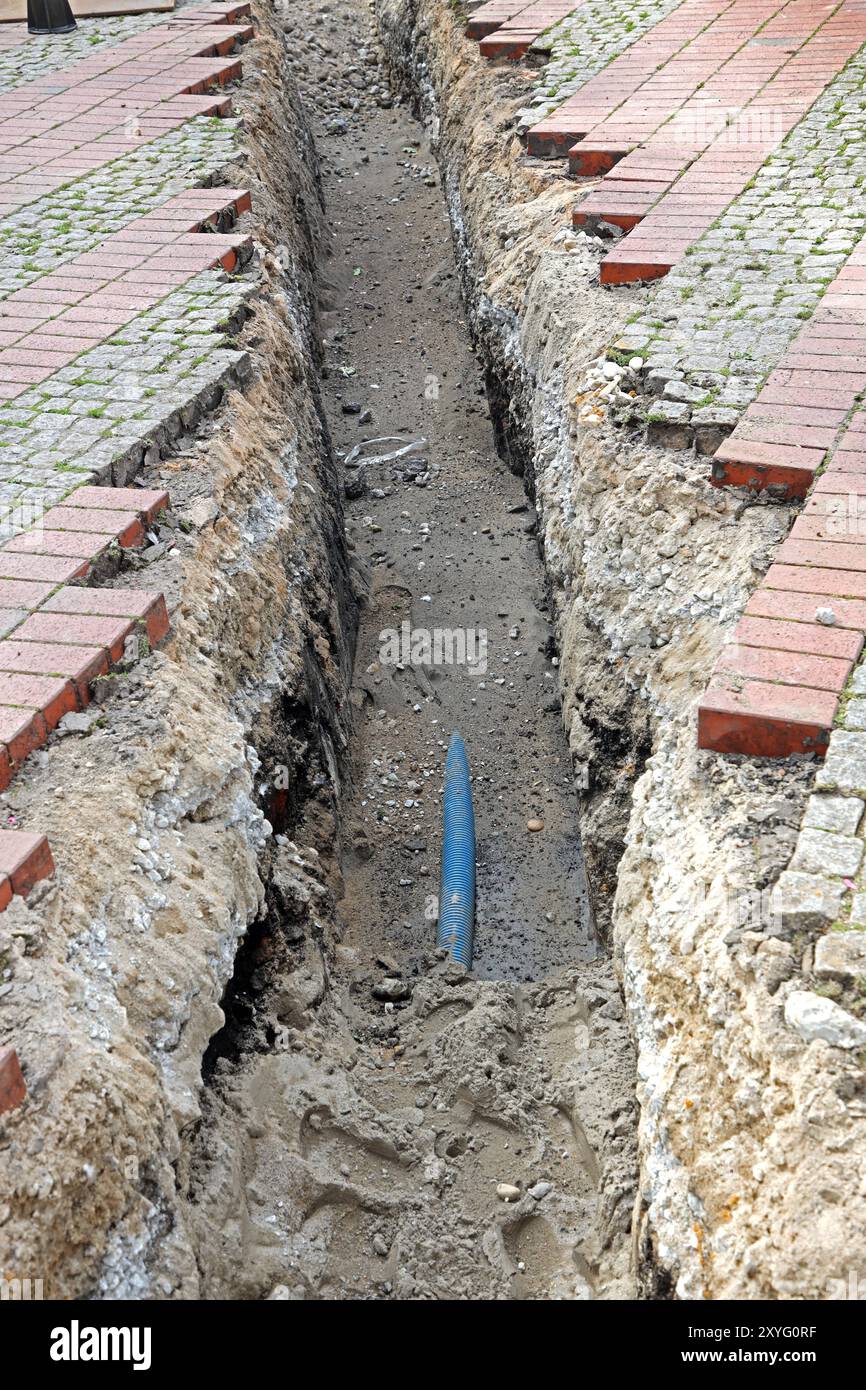 Unverbaute Baugruben Eine schmale und unverbaute Baugrube für Reparaturmaßnahmen an Leitungen **** scavi non rivestiti Una cava di scavo stretta e non rivestita per lavori di riparazione di tubi Foto Stock