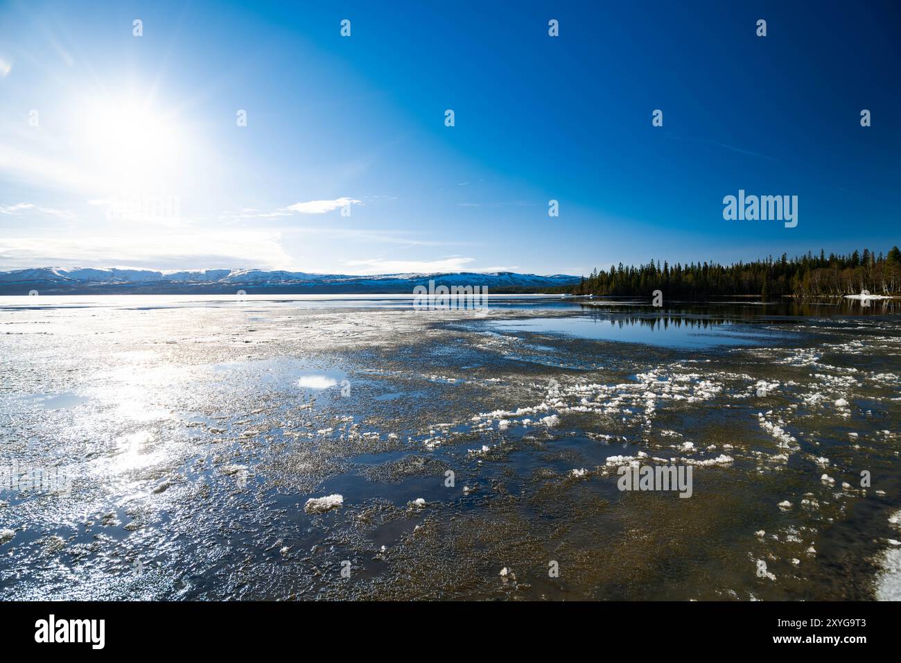 Lago ghiacciato nel nord della Norvegia con montagne sullo sfondo, sfondo paesaggistico Foto Stock