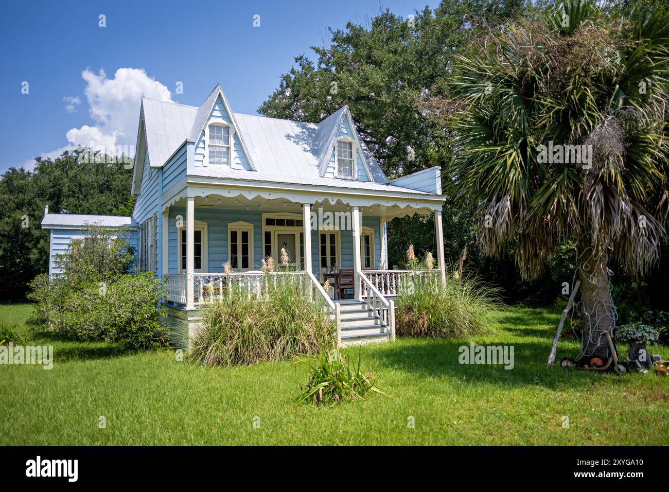 Architettura costiera Casa in legno bianco Sullivan's Island Carolina del Sud // SULLIVAN'S ISLAND, Carolina del Sud, Stati Uniti - Un'affascinante casa in legno bianco sorge su Middle Street, esemplificando la tradizionale architettura costiera che si trova in tutta l'Isola di Sullivan. La struttura ben conservata presenta elementi classici tipici degli edifici residenziali dell'isola, che spesso risalgono alla fine del XIX e all'inizio del XX secolo. Sullivan's Island, un'isola barriera situata all'ingresso del porto di Charleston, ha mantenuto gran parte del suo carattere storico nonostante la sua vicinanza a Charleston. Foto Stock