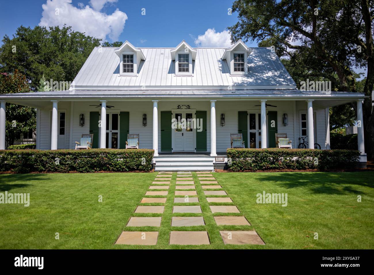 Architettura costiera Casa in legno bianco Sullivan's Island Carolina del Sud // SULLIVAN'S ISLAND, Carolina del Sud, Stati Uniti - Un'affascinante casa in legno bianco sorge su Middle Street, esemplificando la tradizionale architettura costiera che si trova in tutta l'Isola di Sullivan. La struttura ben conservata presenta elementi classici tipici degli edifici residenziali dell'isola, che spesso risalgono alla fine del XIX e all'inizio del XX secolo. Sullivan's Island, un'isola barriera situata all'ingresso del porto di Charleston, ha mantenuto gran parte del suo carattere storico nonostante la sua vicinanza a Charleston. Foto Stock