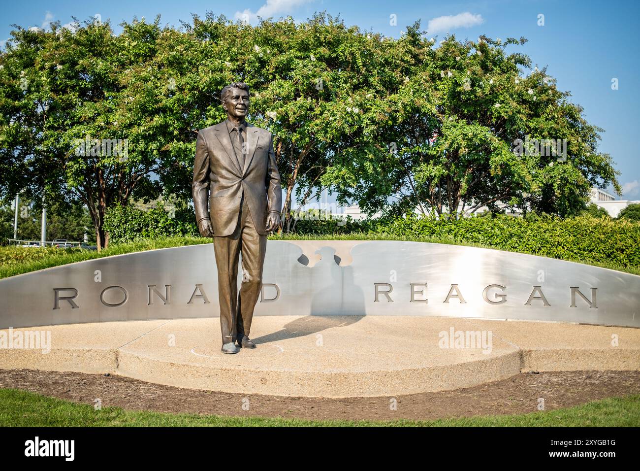 ARLINGTON, Virginia - la statua di Ronald Reagan all'aeroporto nazionale Ronald Reagan di Washington (DCA) commemora il 40° presidente degli Stati Uniti. Creata dal famoso scultore Paul Moore, questa statua in bronzo si erge in modo prominente all'ingresso dell'aeroporto, simboleggiando l'eredità duratura di Reagan e i contributi all'aviazione e alla storia americana. Situato ad Arlington, Virginia, l'aeroporto funge da porta vitale per la capitale della nazione, riflettendo sia il suo significato storico che l'importanza moderna. Foto Stock
