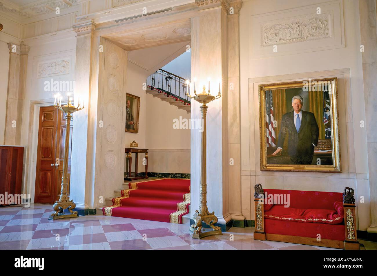 WASHINGTON DC, Stati Uniti - la sala d'ingresso principale della Casa Bianca presenta il ritratto ufficiale del presidente Bill Clinton e fornisce un'occhiata alla grande scalinata che conduce alla residenza privata. Questo spazio formale d'ingresso esemplifica il mix di funzioni governative e dignità residenziale della storica residenza. La sala funge da spazio di transizione tra le aree pubbliche e private della Casa Bianca. Foto Stock