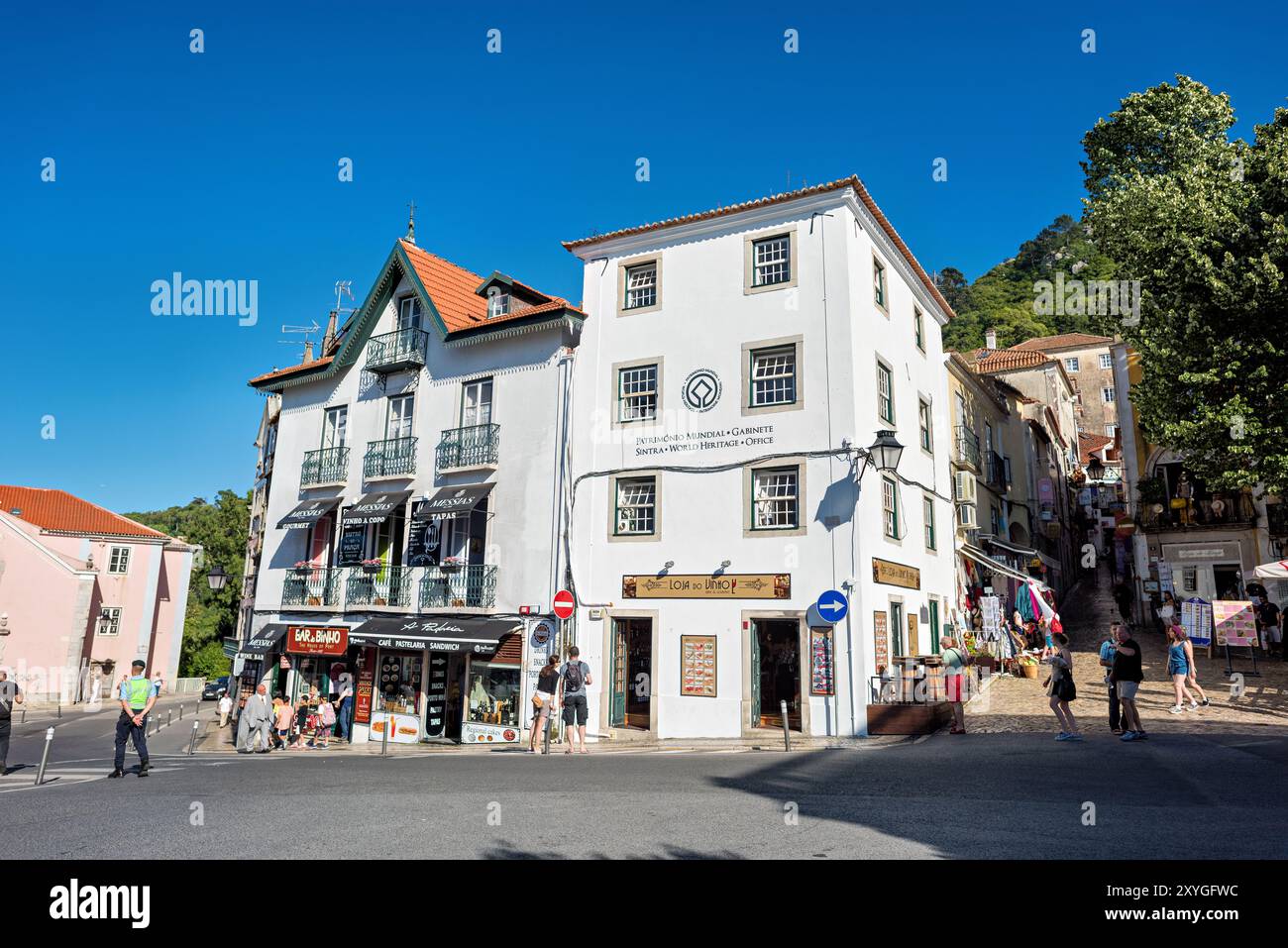 Sintra Architecture and Street Scene Portugal // SINTRA, Portogallo - la storica città di Sintra mette in mostra il suo ricco patrimonio architettonico tra lussureggianti colline verdi. Il Palácio da pena, parte del patrimonio mondiale dell'UNESCO di Sintra, si erge in modo prominente sul paesaggio. Le stradine strette della città presentano un eclettico mix di stili architettonici gotici, moreschi e rinascimentali. Sintra, situata ai piedi delle montagne di Sintra vicino a Lisbona, è stata un rifugio reale sin dal Medioevo. L'area è rinomata per la sua concentrazione di palazzi, tenute e giardini che riflettono secoli di storia Foto Stock