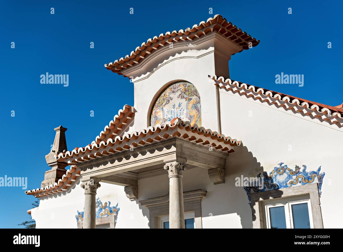 Sintra architettura e piastrelle Sintra Portogallo // SINTRA, Portogallo - la storica città di Sintra mostra il suo ricco patrimonio architettonico tra lussureggianti colline verdi. Il Palácio da pena, parte del patrimonio mondiale dell'UNESCO di Sintra, si erge in modo prominente sul paesaggio. Le stradine strette della città presentano un eclettico mix di stili architettonici gotici, moreschi e rinascimentali. Sintra, situata ai piedi delle montagne di Sintra vicino a Lisbona, è stata un rifugio reale sin dal Medioevo. L'area è rinomata per la sua concentrazione di palazzi, tenute e giardini che riflettono secoli Foto Stock
