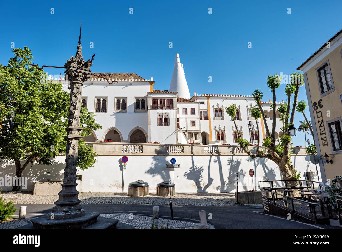 Palácio Nacional de Sintra Twin Chimneys Sintra Portogallo // SINTRA, Portogallo - il Palácio Nacional de Sintra sorge in modo prominente in questa storica città portoghese, riconosciuta come patrimonio dell'umanità dell'UNESCO. Il complesso del palazzo mostra l'evoluzione architettonica delle residenze reali portoghesi, con i suoi caratteristici camini conici gemelli che segnano i quartieri della cucina medievale. Il paesaggio di Sintra presenta un eclettico mix di stili architettonici tra cui elementi gotici, moreschi e rinascimentali attraverso le sue stradine strette e gli edifici collinari. La città servì come rifugio estivo per Portugue Foto Stock