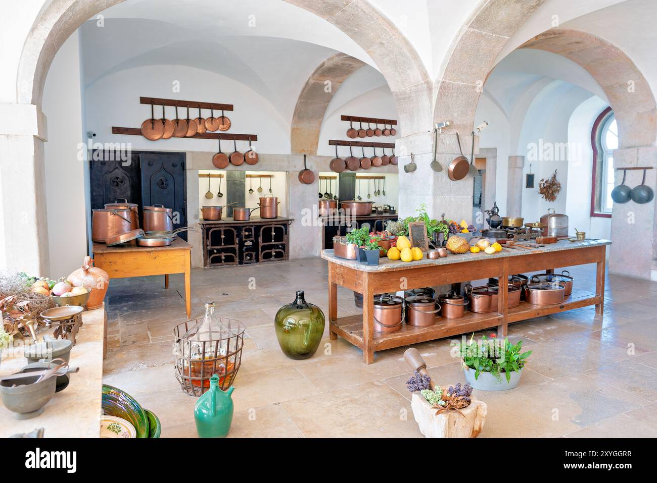 Pena Palace Kitchen pentole in rame Sintra Portugal // SINTRA, Portugal — la grande cucina del pena Palace, che presenta una gamma impressionante di utensili da cucina in rame e attrezzature da cucina del XIX secolo. Questo spazio ben conservato offre ai visitatori uno sguardo sulle operazioni culinarie di una casa reale, con il suo ampio focolare, le piastrelle ornate e gli utensili scintillanti che riflettono il carattere opulento del palazzo e le avanzate tecnologie culinarie dell'epoca. Foto Stock