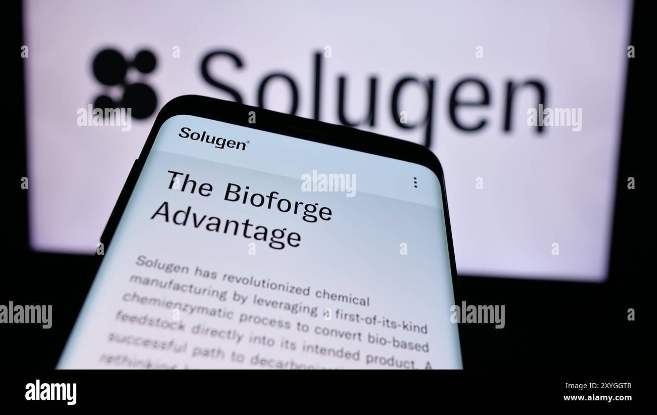 Smartphone con sito Web della società di produzione chimica statunitense Solugen Inc. Davanti al logo aziendale. Mettere a fuoco in alto a sinistra sul display del telefono. Foto Stock