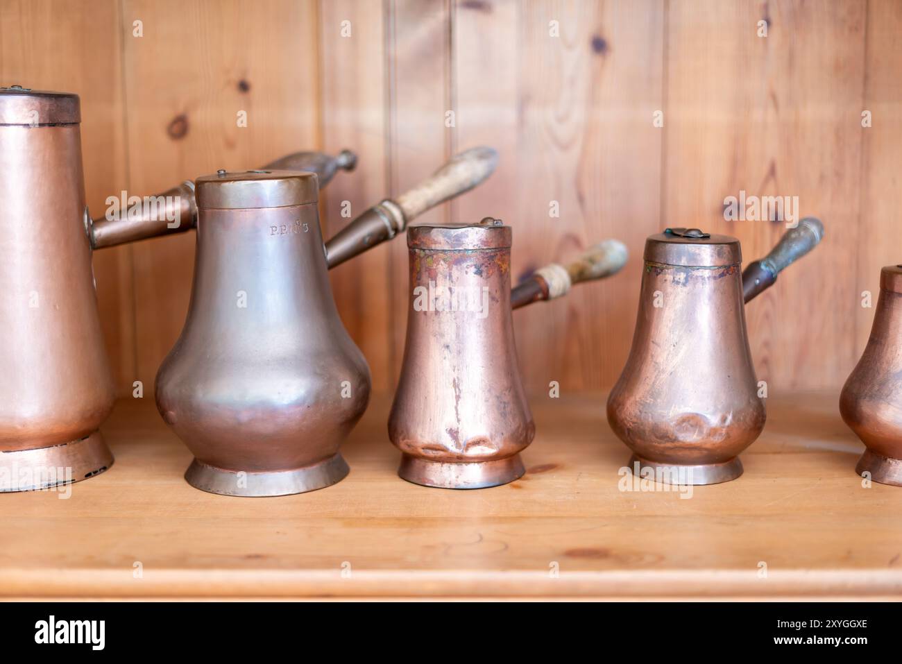 Pentole in rame da cucina di pena Palace Sintra Portugal // SINTRA, Portugal - una serie di pentole e padelle di rame scintillanti esposte nella cucina di pena Palace. Il palazzo romantico del XIX secolo, costruito per re Ferdinando II, presenta cucine d'epoca ben conservate che mostrano l'infrastruttura culinaria necessaria per le operazioni della casa reale. Questi recipienti in rame rappresentano il tipo di pentole di livello professionale comunemente utilizzate nelle cucine aristocratiche dell'epoca. Il Palácio da pena, completato nel 1854, si erge come uno degli esempi più significativi di architettura romantica del Portogallo. Le cucine del palazzo pro Foto Stock