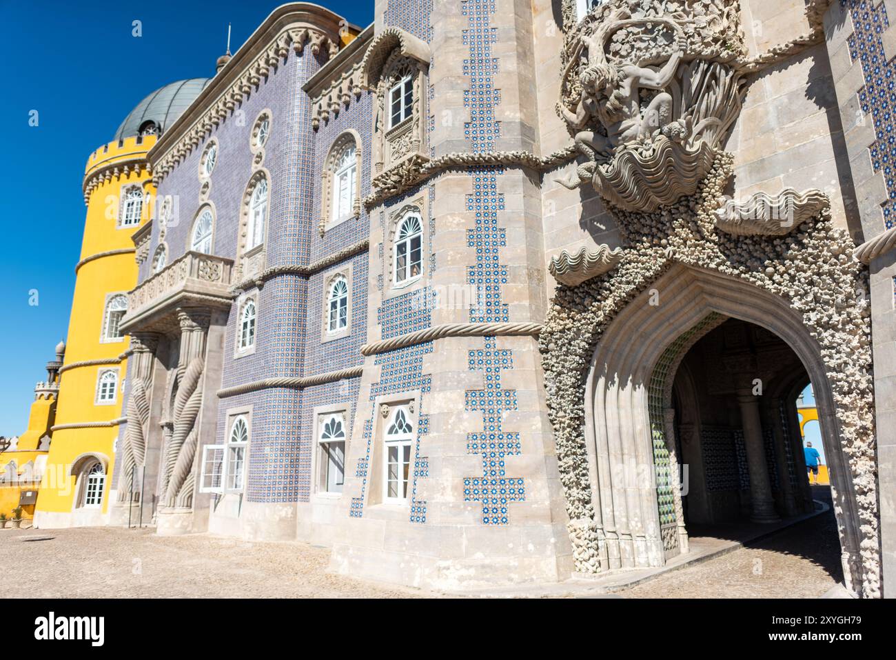 SINTRA, Portogallo, l'iconica statua di Tritone all'ingresso del Palazzo da pena. Questa figura mitologica, mezzo uomo e mezzo pesce, emerge da un arco, che sembra reggere il balcone sopra. Creato dallo scultore portoghese António Teixeira Lopes, il Tritone è un ottimo esempio dello stile romanticista del palazzo e simboleggia la fusione di uomo e natura centrale nella filosofia progettuale del palazzo. Foto Stock