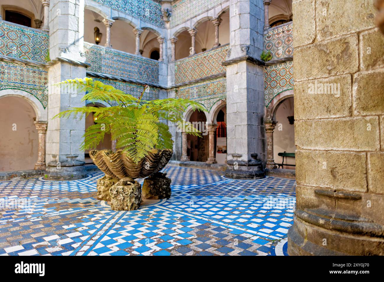 Palazzo pena Manueline Chiostro Sintra Portogallo // SINTRA, Portogallo — il Chiostro Manueline a Palácio pena, originariamente costruito nel 1511, presenta due piani con pareti adornate con piastrelle ispano-moresche del XVI secolo. Durante la conversione del monastero in un palazzo reale, gli archi del chiostro furono chiusi con finestre, che furono poi rimosse negli anni '1930 Le gallerie del chiostro, un tempo parte del monastero di Hieronymite, ora fungono da corridoi che collegano diverse sezioni del palazzo. Lo stile architettonico rappresenta il periodo manuelino portoghese, caratterizzato da ornati Foto Stock