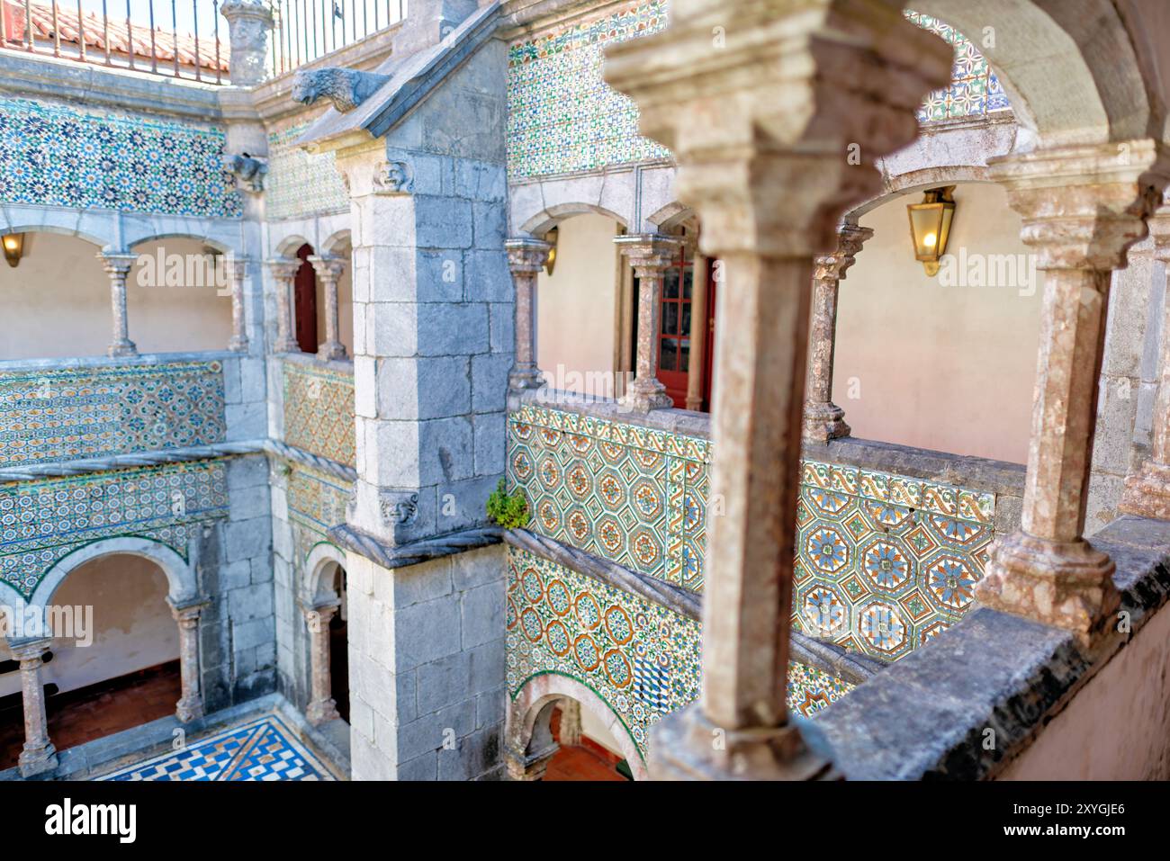 SINTRA, Portogallo - il chiostro manuelino a Palazzo pena, originariamente costruito nel 1511, presenta due piani con pareti adornate con piastrelle ispano-moresche del XVI secolo. Durante la conversione del monastero in un palazzo reale, gli archi del chiostro furono chiusi con finestre, che furono poi rimosse negli anni '1930 Le gallerie del chiostro, un tempo parte del monastero, ora fungono da corridoi nel palazzo. Foto Stock