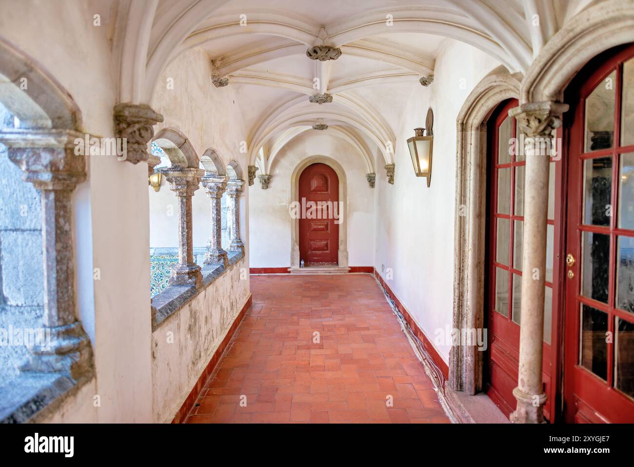 Palazzo pena Manueline Chiostro Sintra Portogallo // SINTRA, Portogallo — il Chiostro Manueline a Palácio pena, originariamente costruito nel 1511, presenta due piani con pareti adornate con piastrelle ispano-moresche del XVI secolo. Durante la conversione del monastero in un palazzo reale, gli archi del chiostro furono chiusi con finestre, che furono poi rimosse negli anni '1930 Le gallerie del chiostro, un tempo parte del monastero di Hieronymite, ora fungono da corridoi che collegano diverse sezioni del palazzo. Lo stile architettonico rappresenta il periodo manuelino portoghese, caratterizzato da ornati Foto Stock