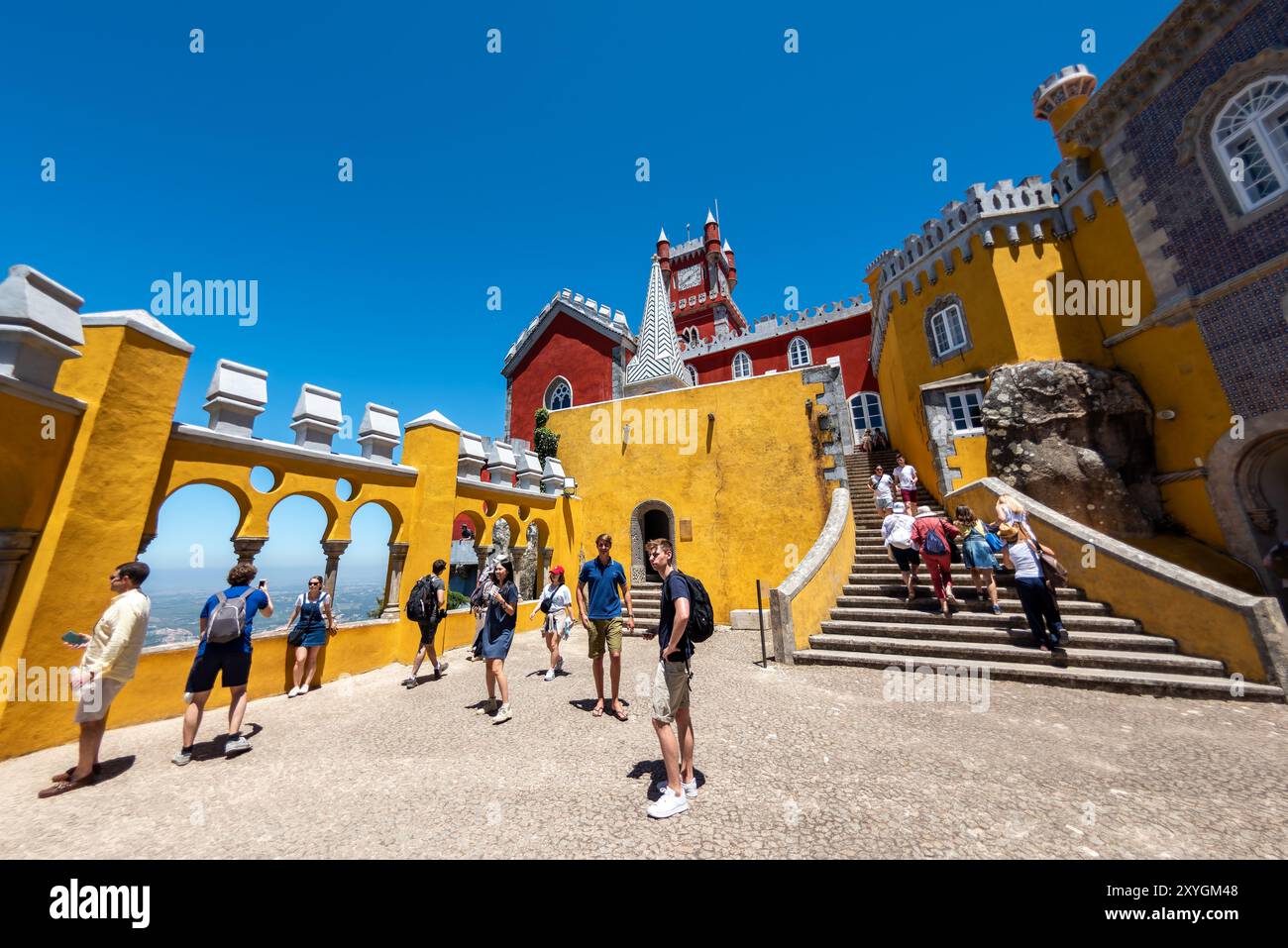 Cortile degli archi di Palácio da pena Sintra Portogallo // SINTRA, Portogallo - il cortile degli archi di Palácio da pena mette in mostra elementi architettonici moreschi all'interno di questo palazzo romanticista del XIX secolo. Il cortile ad arco fa parte del Palácio da pena, che fu costruito nel 1840 sulle rovine di un monastero medievale nei Monti Sintra. Il palazzo è una delle sette meraviglie del Portogallo ed è situato all'interno del paesaggio culturale di Sintra, dichiarato patrimonio dell'umanità dall'UNESCO nel 1995. Il Palácio da pena fu commissionato da re Ferdinando II e rappresenta uno dei più bei esempi d'Europa Foto Stock