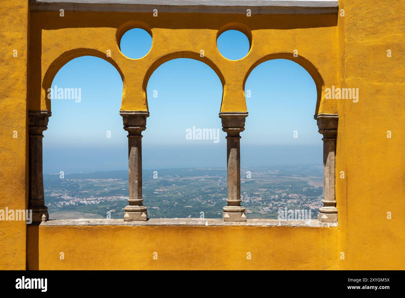 Cortile degli archi di Palácio da pena Sintra Portogallo // SINTRA, Portogallo - il cortile degli archi di Palácio da pena mette in mostra elementi architettonici moreschi all'interno di questo palazzo romanticista del XIX secolo. Il cortile ad arco fa parte del Palácio da pena, che fu costruito nel 1840 sulle rovine di un monastero medievale nei Monti Sintra. Il palazzo è una delle sette meraviglie del Portogallo ed è situato all'interno del paesaggio culturale di Sintra, dichiarato patrimonio dell'umanità dall'UNESCO nel 1995. Il Palácio da pena fu commissionato da re Ferdinando II e rappresenta uno dei più bei esempi d'Europa Foto Stock