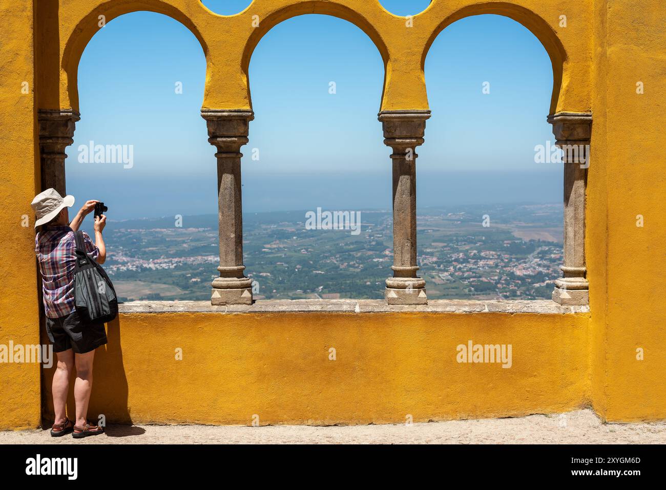 Cortile degli archi di Palácio da pena Sintra Portogallo // SINTRA, Portogallo - il cortile degli archi di Palácio da pena mette in mostra elementi architettonici moreschi all'interno di questo palazzo romanticista del XIX secolo. Il cortile ad arco fa parte del Palácio da pena, che fu costruito nel 1840 sulle rovine di un monastero medievale nei Monti Sintra. Il palazzo è una delle sette meraviglie del Portogallo ed è situato all'interno del paesaggio culturale di Sintra, dichiarato patrimonio dell'umanità dall'UNESCO nel 1995. Il Palácio da pena fu commissionato da re Ferdinando II e rappresenta uno dei più bei esempi d'Europa Foto Stock