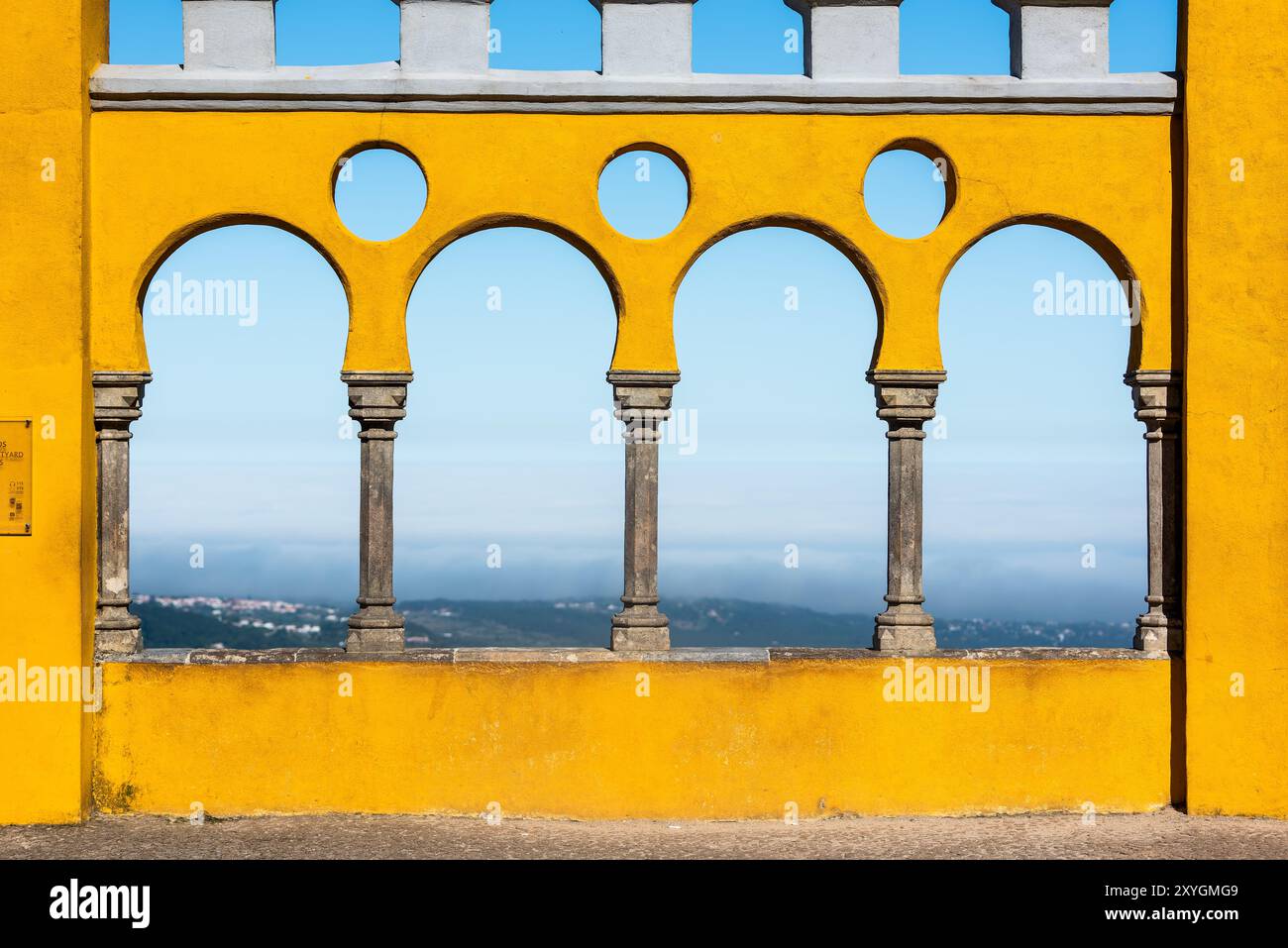 Cortile degli archi di Palácio da pena Sintra Portogallo // SINTRA, Portogallo - il cortile degli archi di Palácio da pena mette in mostra elementi architettonici moreschi all'interno di questo palazzo romanticista del XIX secolo. Il cortile ad arco fa parte del Palácio da pena, che fu costruito nel 1840 sulle rovine di un monastero medievale nei Monti Sintra. Il palazzo è una delle sette meraviglie del Portogallo ed è situato all'interno del paesaggio culturale di Sintra, dichiarato patrimonio dell'umanità dall'UNESCO nel 1995. Il Palácio da pena fu commissionato da re Ferdinando II e rappresenta uno dei più bei esempi d'Europa Foto Stock